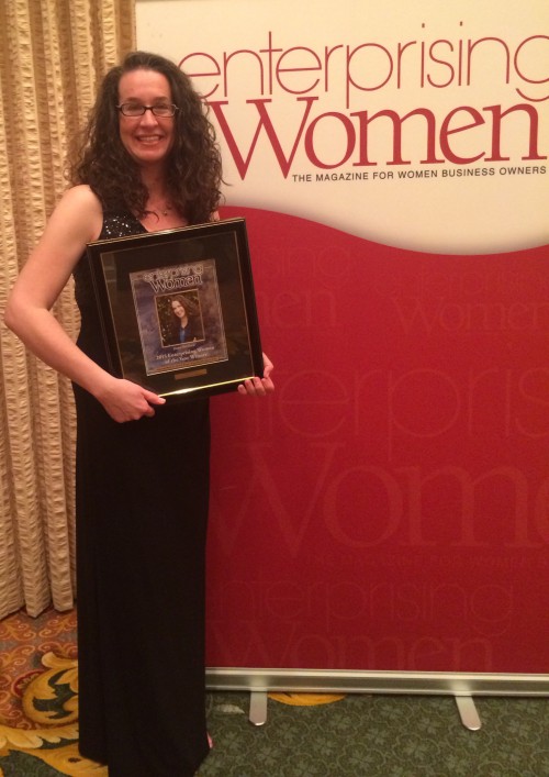 Dana Marlowe holding a plaque from the Enterprising Women Awards