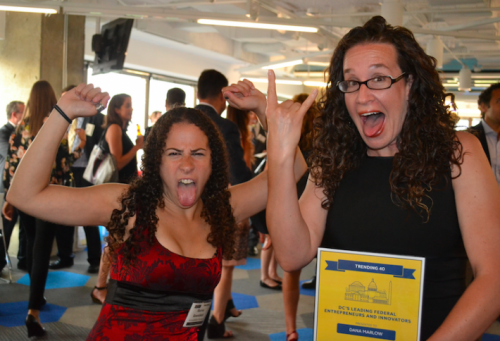 Sharon and Dana making silly faces and flexing with Dana's Trending 40 Award