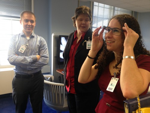 Sharon trying on Google Glass with coworkers nearby