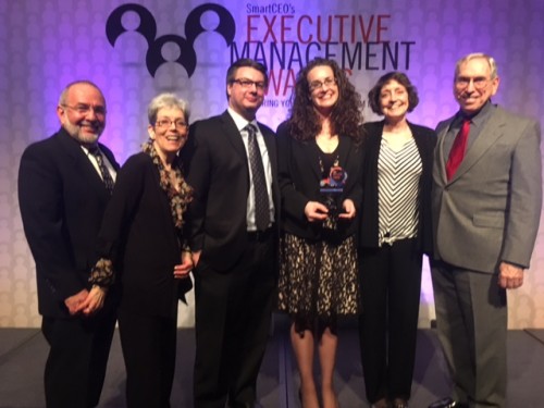 Dana with her family with award backdrop